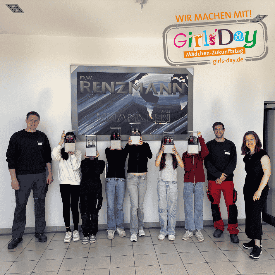Gruppe beim Girls’Day mit Werkstücken vor Firmenlogo